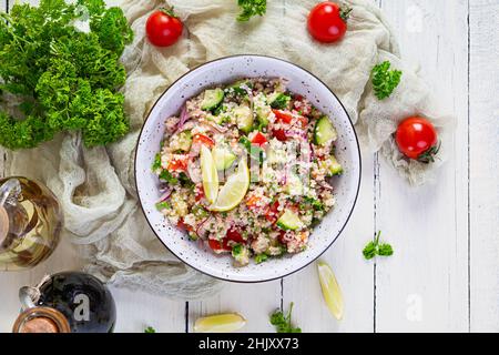 Insalata di tovouleh vegetariana con couscous, prezzemolo, cetriolo, pomodoro. Cucina tradizionale mediorientale o arabica Foto Stock