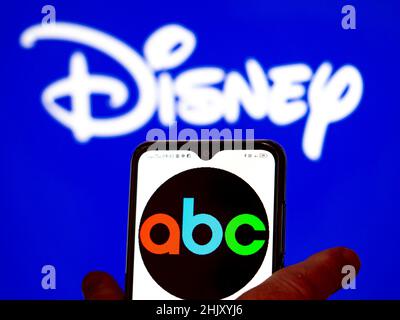 In questa figura, il logo ABC viene visualizzato sullo schermo dello smartphone con il logo Dyney sullo sfondo. Foto Stock