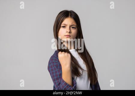 Ritratto closeup pazza giovane ragazza che sta per avere disgregazione atomica nervosa, pugno in aria, arrabbiato con qualcuno sfondo grigio isolato.
