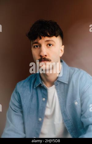 Ritratto di uomo sicuro su sfondo marrone Foto Stock