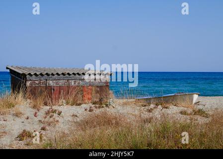 Rusty Beach capanna e vecchio peschereccio sulla spiaggia in Corsica, Francia. Foto di alta qualità Foto Stock