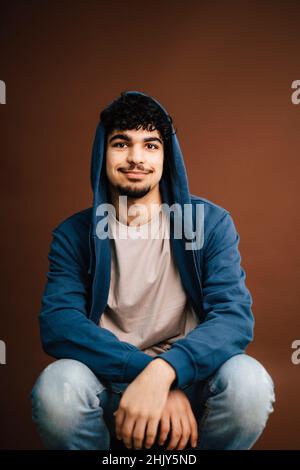 Ritratto di uomo seduto in studio Foto Stock