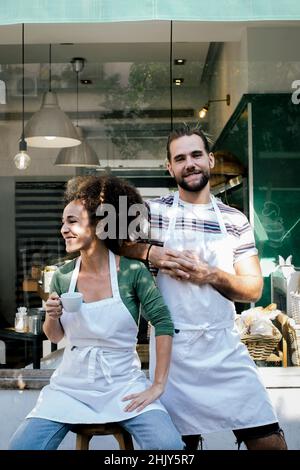 Sorridenti proprietari di uomini e donne fuori dal bar Foto Stock