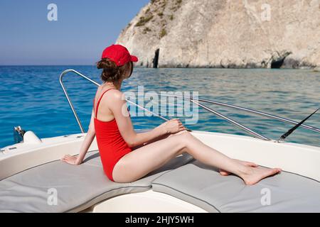 Donna in costume da bagno rosso nuotando dallo yacht di Zante Foto Stock