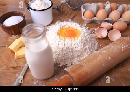 Farina di grano con uova, latte, burro. Ingredienti per cuocere il pane, la pizza o la torta Foto Stock