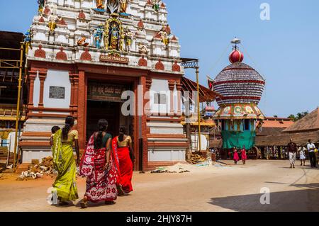 Udupi, Karnataka, India : un gruppo di donne cammina verso la torre di gopuram del tempio di Krishna del 13th secolo. Il tempio fu fondato dal locale Hin Foto Stock