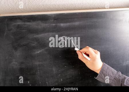 Ragazzo calcola e scrive su una lavagna Foto Stock