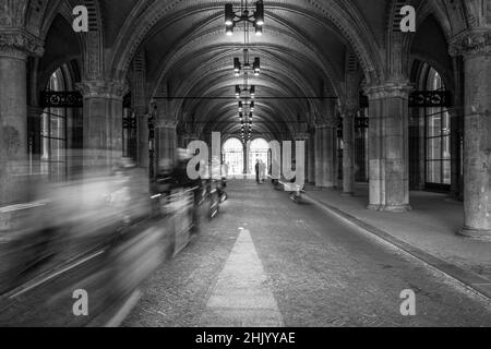 Ciclisti bianchi e neri sotto gli archi del Rijksmuseum Amsterdam Holland Foto Stock