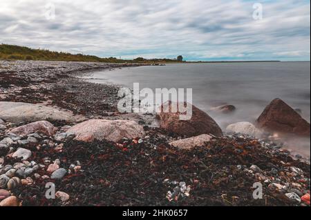 Spiaggia di pietra dall'isola del Mar Baltico Fehmarn con vista sul Puttgarden Foto Stock