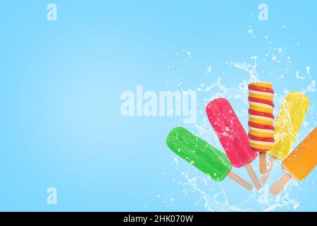 Un gelato a pistoncini colorati spruzzi su sfondo blu con spazio per la copia. Foto Stock