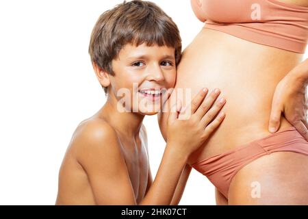 Felice futuro fratello abbracciare la pancia incinta della mamma Foto Stock