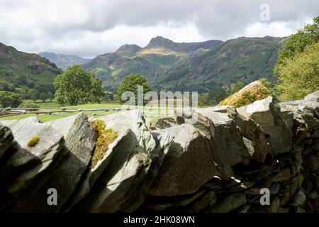 vista della valle di langdale e dei pikes di langdale dal pavimento della valle che guarda sopra il muro di pietra asciutto vicino al capello style, distretto del lago, cumbria, inghilterra, u Foto Stock