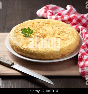 Tradizionale frittata spagnola con patate e cipolla su sfondo rustico scuro. Tapas spagnole. Foto Stock