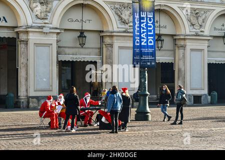 Una piccola band vestita da Babbo Natale e che suona canzoni natalizie in Piazza San Carlo durante le festività natalizie, Torino, Piemonte, Italia Foto Stock