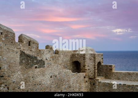 Mura difensive a Monemvasia Island, Peloponneso, Grecia al Tramonto. La città medievale del castello termina sul mare. Foto Stock