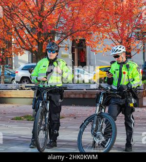 Poliziotto polizia in bicicletta in una città. Due poliziotti pattugliano sulle loro bici su una strada di un Vancouver BC Foto Stock
