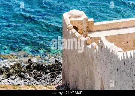 Mura difensive nell'isola di Monemvasia, Peloponneso, Grecia. La città medievale del castello termina al mare azzurro. Foto Stock