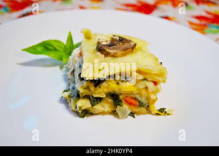 Lasagna vegetale cremosa servita su un piatto bianco Foto Stock