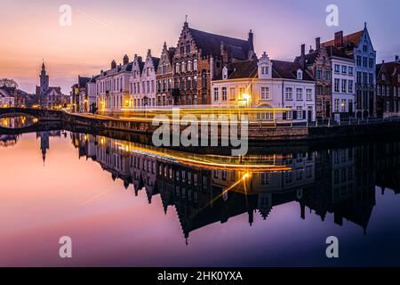 Tramonto spettacolare con sentieri di luci sulle vecchie strade storiche e i canali della città di Bruges. Foto scattata il 24th gennaio 2022 a Bruges, Pr Foto Stock