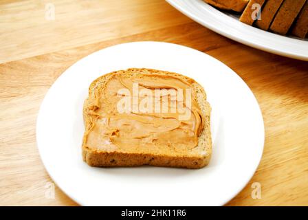 Burro di arachidi spalmato su pane di grano Foto Stock