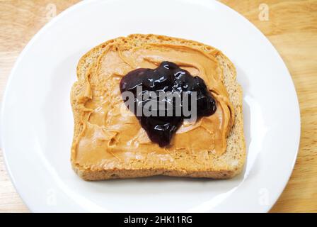 Preparazione di un burro di arachidi e sandwich di gelatina Foto Stock