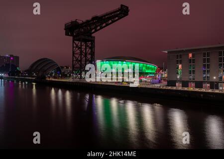 La Finnieston Crane sul fiume Clyde con l'arena coperta polivalente Hydro illuminata in verde sullo sfondo. Foto Stock