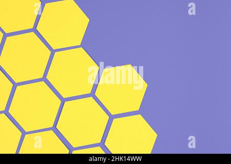 composizione geometrica con esagoni di carta gialli su sfondo viola Foto Stock