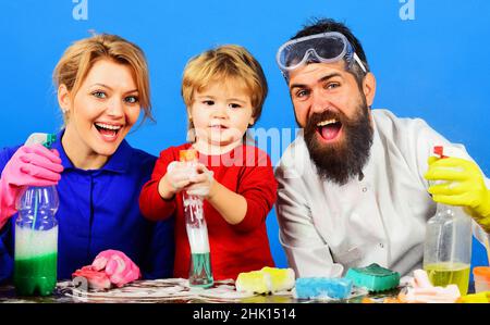 Giorno di pulizia. Happy Family pulisce insieme in casa. Bambino carino che gioca con lo spray di compensazione. Foto Stock