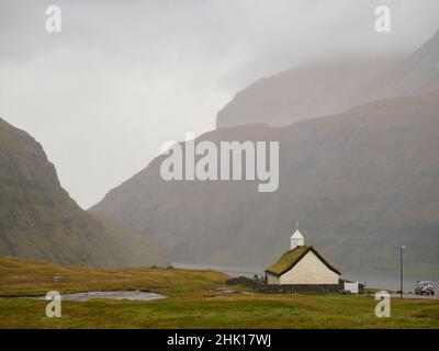 Tipica chiesa in cima a un tappeto erboso nel villaggio di Saksun, Streymoy, Isole Faroe, Danimarca, Nord Europa Foto Stock