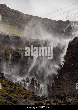 Primo piano per la cascata Fossa (Fossá) durante il vento forte in tempo piovoso, Streymoy Island, Isole Faroe, Danimarca - Gasadalur Mulafossur Waterfall Foto Stock
