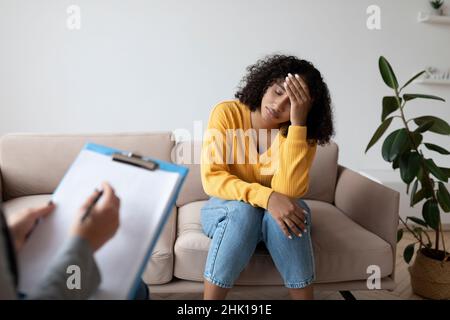 Donna nera depressa che ha consultato lo psicologo, che soffre di PTSD alla clinica mentale Foto Stock
