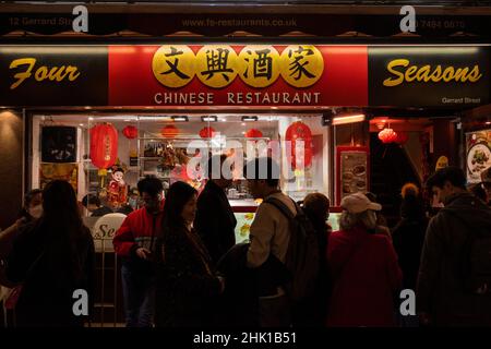 Londra, Regno Unito. 1 febbraio 2022. Persone fuori dal ristorante Four Season a Chinatown la sera del Capodanno cinese come l'anno della Tigre ufficialmente inizia. I festeggiamenti a Chinatown sono ridimensionati quest'anno a causa della pandemia, ma i ristoranti sperano che le aziende riprendano ora che le restrizioni del piano B Omicron sono state allentate dal governo britannico. Credit: Stephen Chung / Alamy Live News Foto Stock