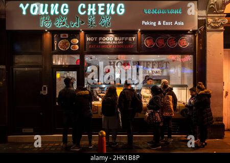 Londra, Regno Unito. 1 febbraio 2022. Le persone si accodano fuori dal ristorante a buffet di cibo caldo Young Cheng a Chinatown la sera del Capodanno cinese, come inizia ufficialmente l'anno della Tigre. I festeggiamenti a Chinatown sono ridimensionati quest'anno a causa della pandemia, ma i ristoranti sperano che le aziende riprendano ora che le restrizioni del piano B Omicron sono state allentate dal governo britannico. Credit: Stephen Chung / Alamy Live News Foto Stock