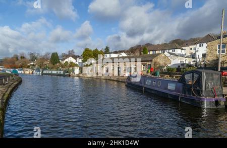 Chiatte ormeggiate sul canale Leeds Liverpool in cima alle cinque chiuse a Bingley, Yorkshire. Il Five Rise Locks Cafe e' sullo sfondo. Foto Stock