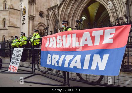 Londra, Regno Unito. 01st Feb 2022. Gli ufficiali di polizia si trovano accanto a una bandiera britannica insulata durante la protesta al di fuori delle corti reali di giustizia.19 insultano gli attivisti britannici sono in processo per aver infrantito l'ingiunzione del M25. Quattro attivisti saltarono la loro audizione e si incollarono ai gradini all'ingresso dei tribunali. La Gran Bretagna, isolata, chiede al governo di garantire che tutte le case del Regno Unito siano più efficienti dal punto di vista energetico entro il 2030. Credit: SOPA Images Limited/Alamy Live News Foto Stock