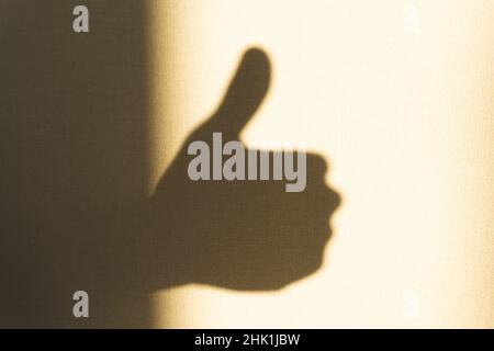 L'ombra della mano mostra il pollice verso l'alto Foto Stock