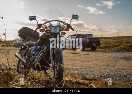 Moto parcheggiato all'aperto, Closeup di moto in autunno giorno di sole Foto Stock