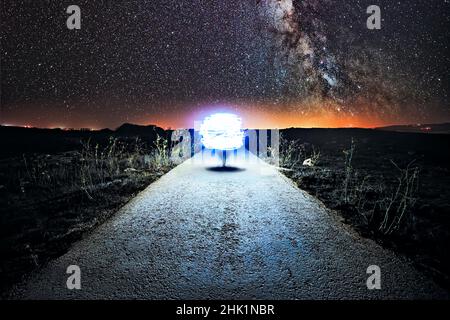 Un'astronave simile ad un orb atterra su una tranquilla strada rurale Foto Stock