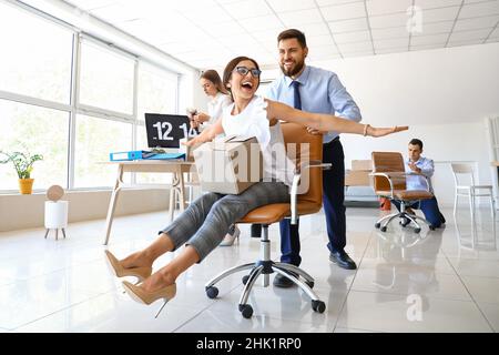 I colleghi di lavoro si divertono mentre si imballano le cose in ufficio il giorno in movimento Foto Stock