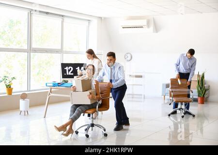 I colleghi di lavoro si divertono mentre si imballano le cose in ufficio il giorno in movimento Foto Stock