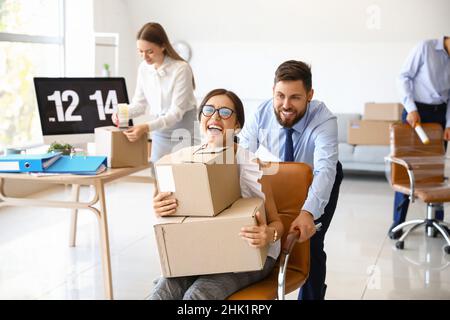 I colleghi di lavoro si divertono mentre si imballano le cose in ufficio il giorno in movimento Foto Stock