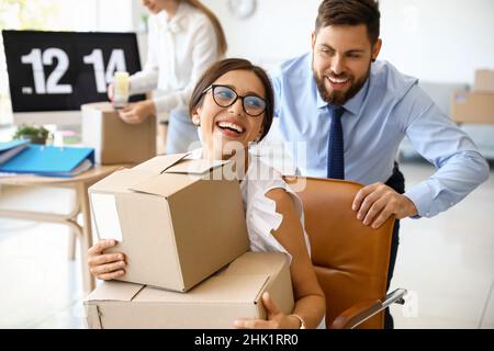 I colleghi di lavoro si divertono mentre si imballano le cose in ufficio il giorno in movimento Foto Stock