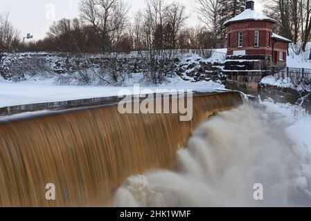 Helsinki, Finlandia - 10 marzo 2021: L'acqua si riversa sulla diga congelata del museo nella foce del fiume Vantaa alle rapide di Vanhankaupunginkoski (Vanhankaupungi Foto Stock