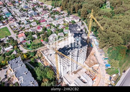 costruzione di un alto edificio di appartamenti nell'area residenziale di sobborgo. vista aerea dall'alto. Foto Stock