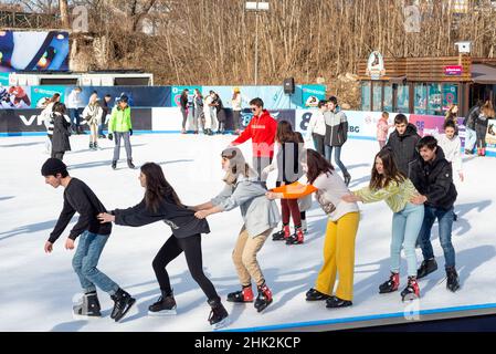 Gli adolescenti godono del sole invernale in una pista di pattinaggio su ghiaccio all'aperto a Sofia, Bulgaria, Europa orientale, Balcani, UE Foto Stock