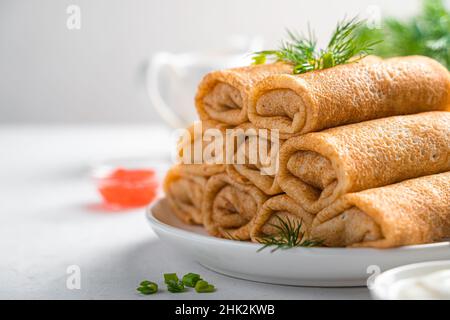Deliziose frittelle ripiene con carne da vicino. Pancake sottili con ripieno. Un piatto tradizionale russo per Maslenitsa. Foto Stock