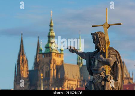 Statua di San Giovanni Battista sul Ponte Carlo con il Castello di Praga e la Cattedrale di San Vito lo sfondo, Praga, capitale della Repubblica Ceca, UNE Foto Stock