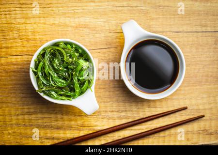 Wakame verde. Insalata di alghe e salsa di soia in ciotola. Vista dall'alto. Foto Stock