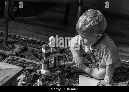 Bambino curioso di costruire blocco giocattolo. (SIG.) Foto Stock