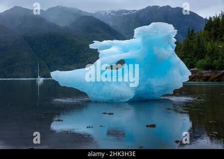 USA, Alaska, Gulf 32 Pilothouse barca a vela all'ancora vicino a grandi iceberg dal ghiacciaio di LeConte collegato a bassa marea nella baia di LeConte la sera d'estate Foto Stock